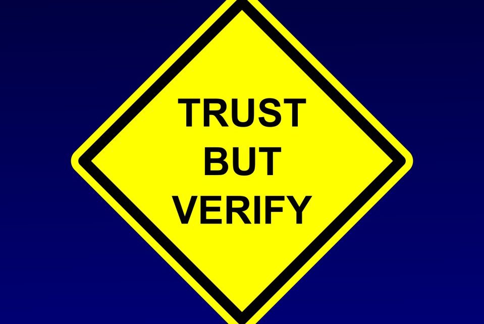 Street sign made to say Trust But Verify